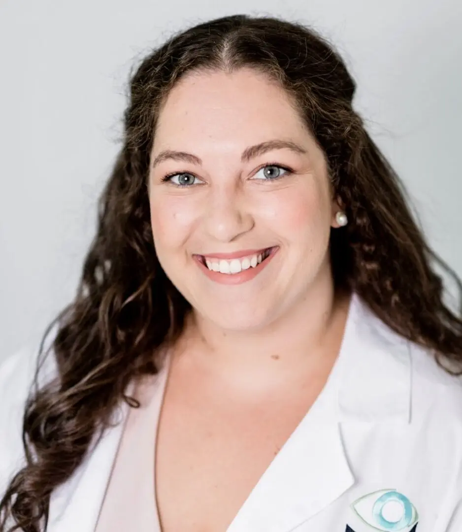 A woman in white lab coat smiling for the camera.