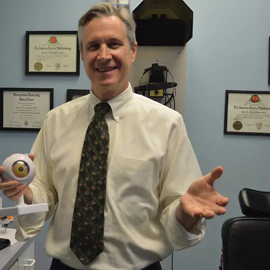 A man in a white shirt and tie holding a small toy.