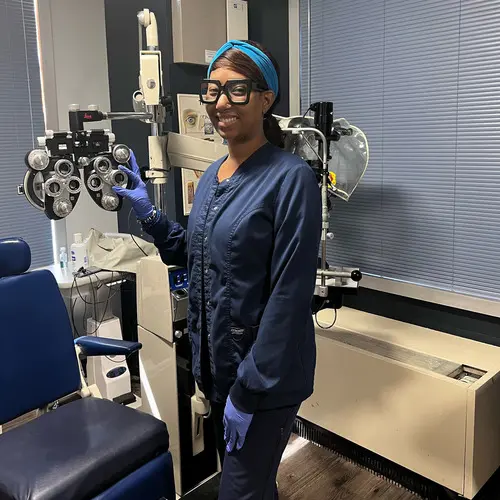 A woman holding an eye test in her hand.