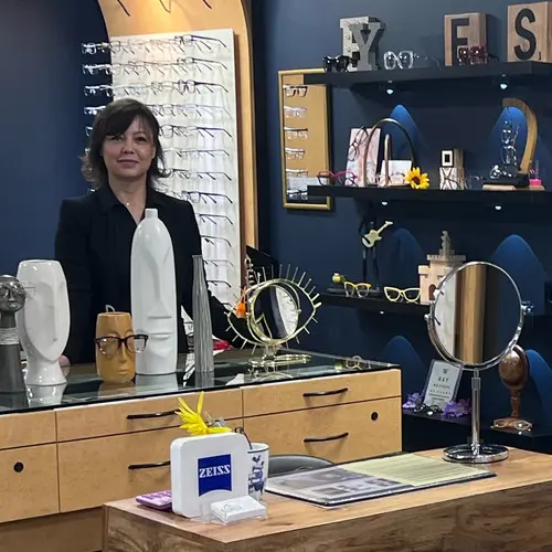 A woman standing in front of an eye care counter.