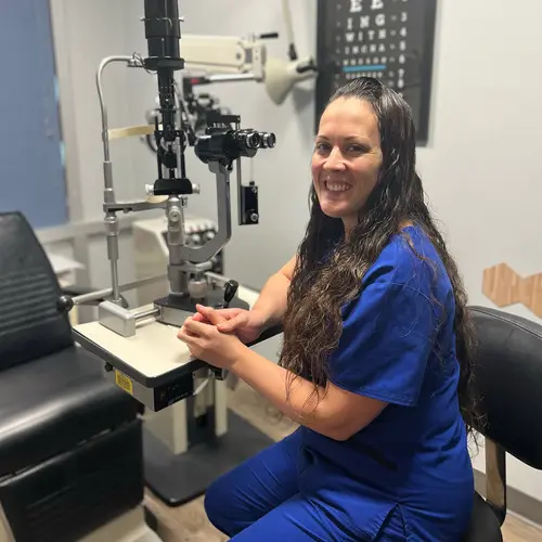 A woman sitting in front of an eye exam machine.